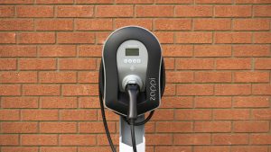 Black myenergi Zappi EV charger against a brick wall